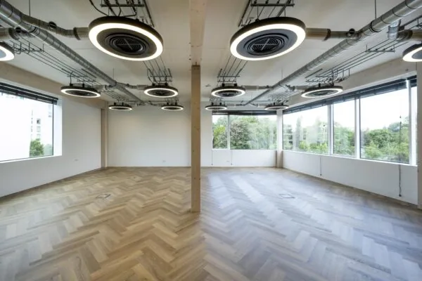 Licht en modern kantoorinterieur aan de Fred. Roeskestraat met visgraatvloer, grote ramen en opvallende ronde plafondlampen.